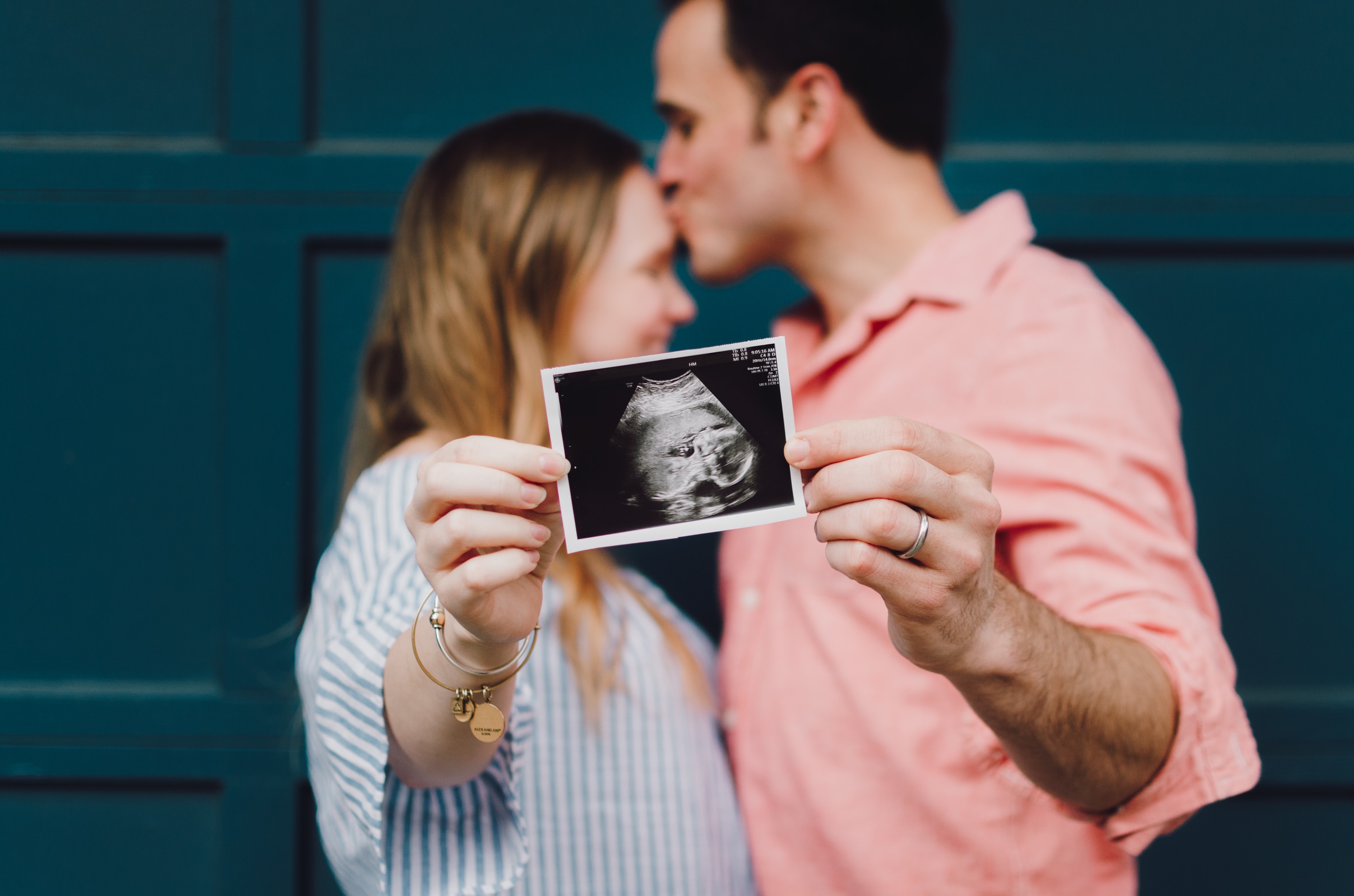 man and woman holding ultrasound image