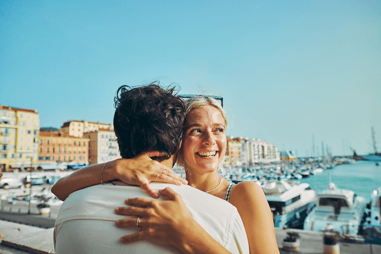 couples embracing on pedestrian bridge viewing marina